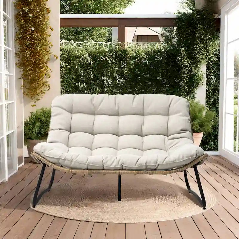 Ce fauteuil double en rotin est livré avec un coussin et convient aussi bien à une utilisation intérieure qu'extérieure.