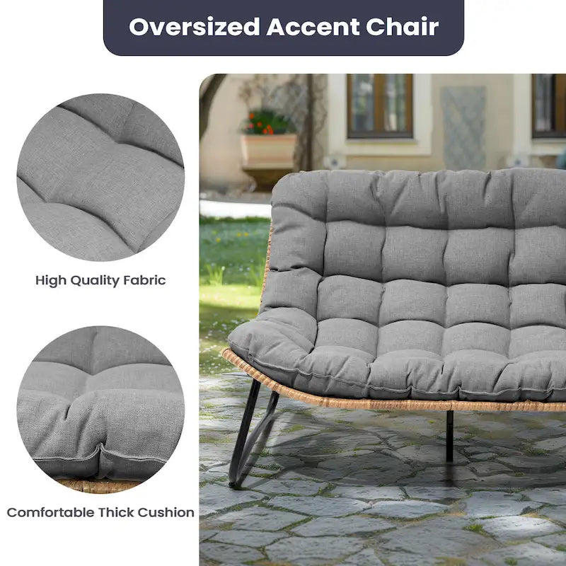 Ce fauteuil double en rotin est livré avec un coussin et convient aussi bien à une utilisation intérieure qu'extérieure.