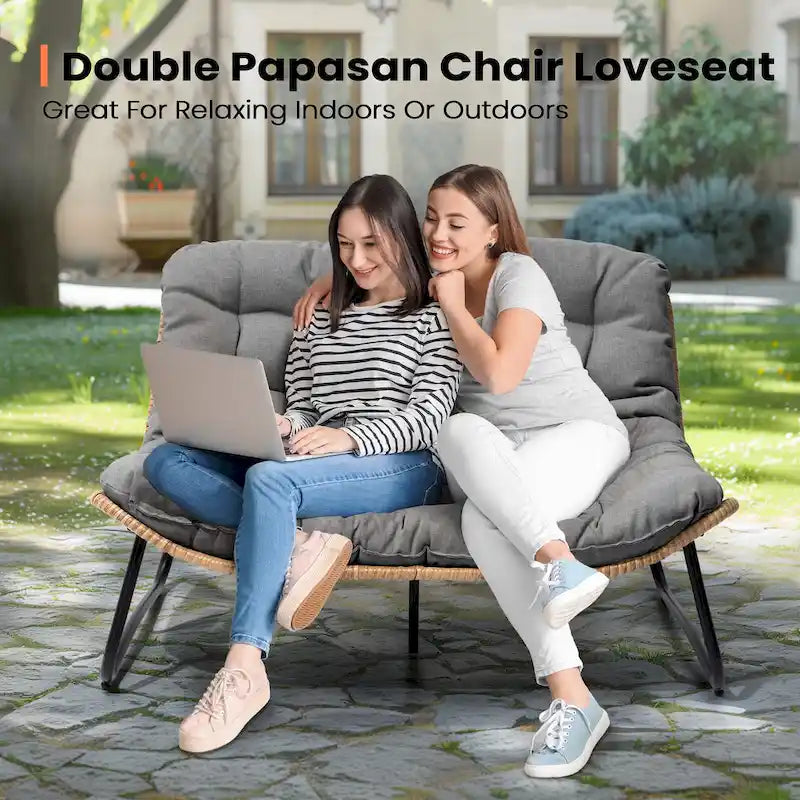 Ce fauteuil double en rotin est livré avec un coussin et convient aussi bien à une utilisation intérieure qu'extérieure.